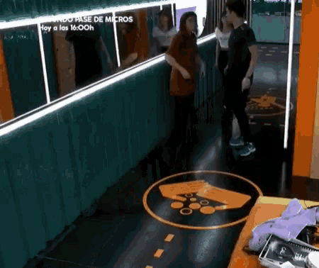 a group of people are standing in a hallway with a sign on the floor that says ' cuando pase de micros '