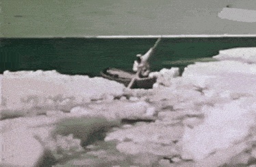 a black and white photo of a man in a boat in the ocean .