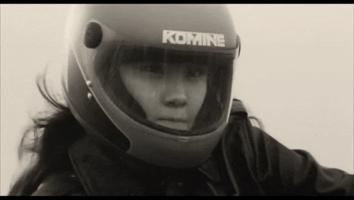 a woman wearing a komine motorcycle helmet