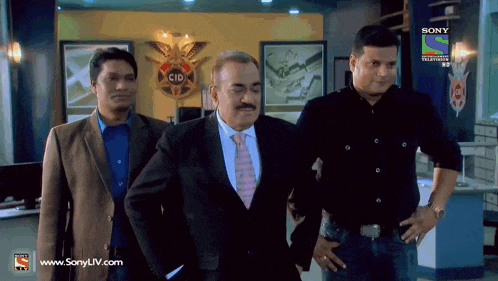 three men are standing in front of a sign that says cid on it