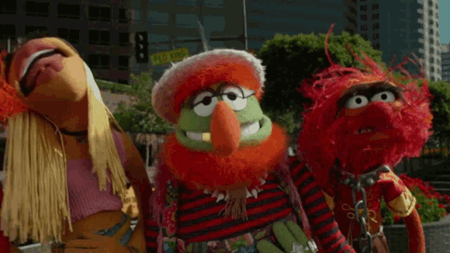 a group of sesame street characters are standing on a street