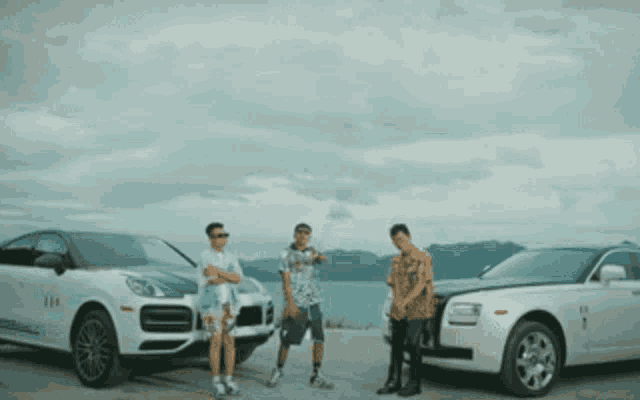 three men standing in front of a row of cars