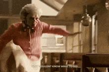 a man in a red shirt is dancing in a kitchen and says very couldn t know what to do
