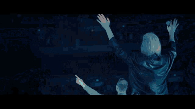 a man singing into a microphone with a blue background