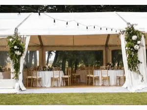 a wedding tent with tables and chairs set up for a wedding reception .