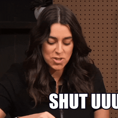 a woman in a black shirt is saying shut uuu