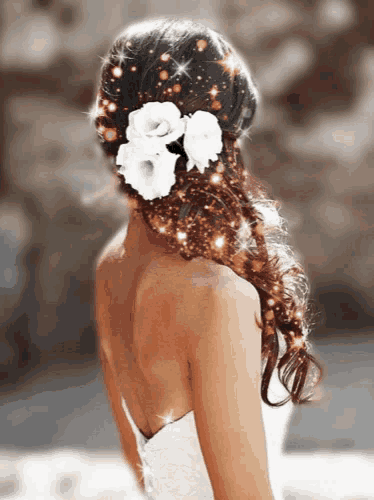 a woman wearing a white dress has flowers in her hair