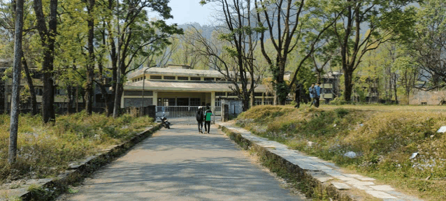 two people walking down a path in front of a building