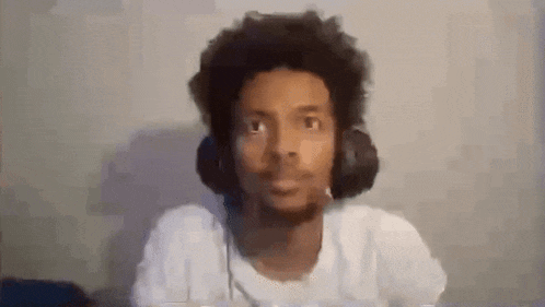 a man wearing headphones and a microphone is looking at the camera .
