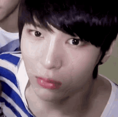 a close up of a young man 's face with a striped shirt and red lipstick .