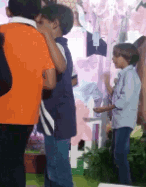a group of children are standing in a room with a pink background