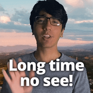 a man wearing glasses and a gray shirt says long time no see