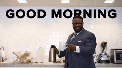 a man in a suit is holding a cup of coffee in front of a good morning sign .