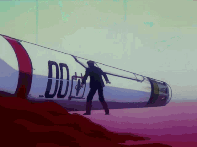 a man in a suit is standing in front of a rocket with the letter dd on it