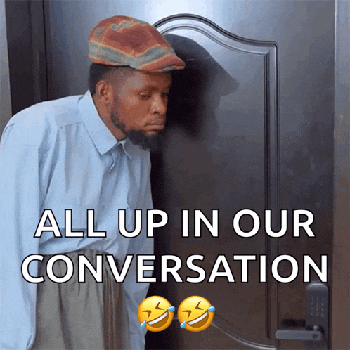 a man in a hat is standing in front of a door with the words all up in our conversation above him