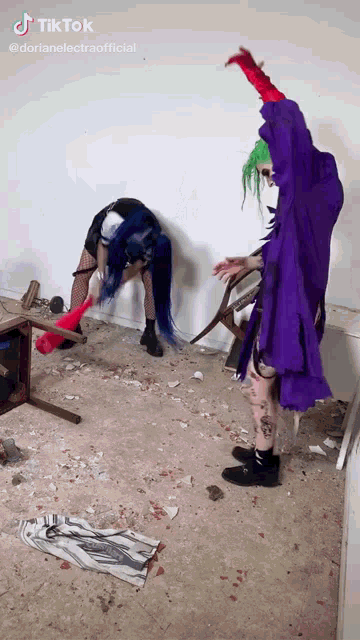 a man in a purple robe is standing next to a woman in a blue wig .