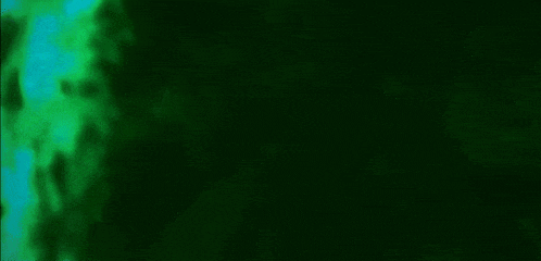 a green and blue background with a blurred image of a person walking in the dark .