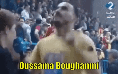 a man in a yellow shirt is standing in front of a crowd and says ousama boughnami