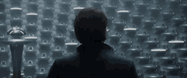 a man is standing in front of a row of empty chairs