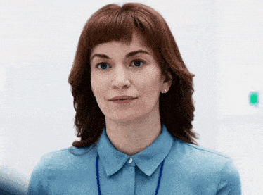 a woman with red hair is wearing a blue shirt