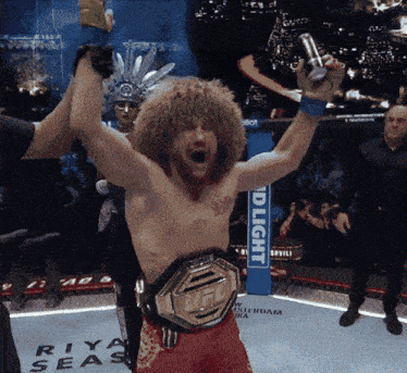 a man in a boxing ring with a bud light sign behind him