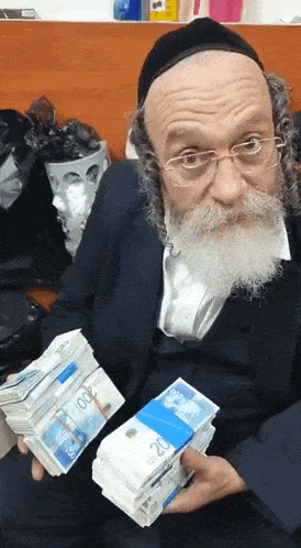 a man with glasses and a beard is holding a stack of money with the number 20 on it