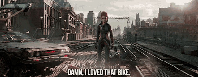 a woman standing on a train track with the words damn i loved that bike above her