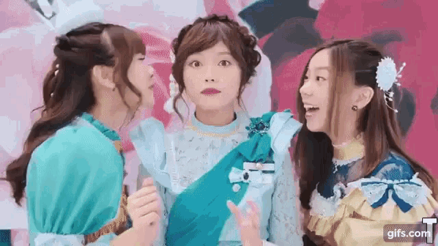 three women are standing next to each other and talking to each other .