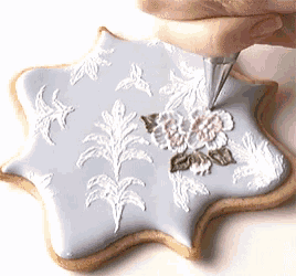 a person is decorating a cookie with a piping bag