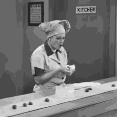 a woman in a chef 's hat is standing in front of a sign that says kitchen
