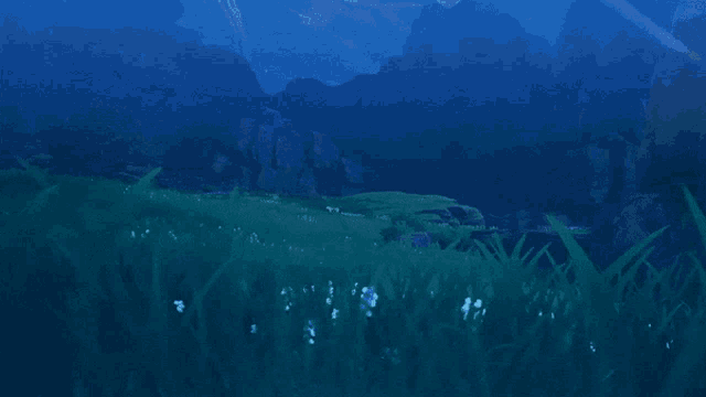 a blue sky with mountains in the background and a field of grass