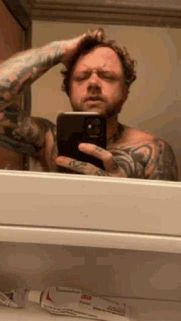 a man taking a selfie in front of a mirror