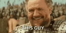 a man in armor is smiling in front of a crowd of people and says `` this guy '' .
