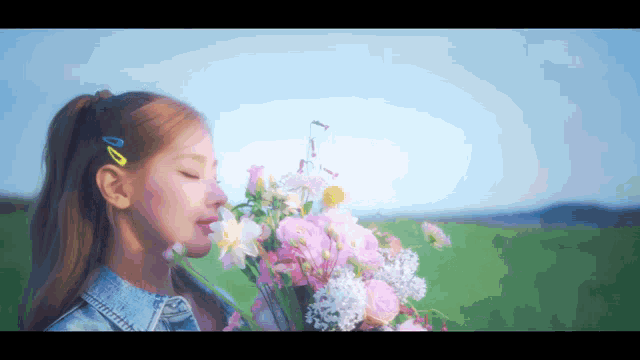 a woman is holding a bouquet of pink flowers in her hand .