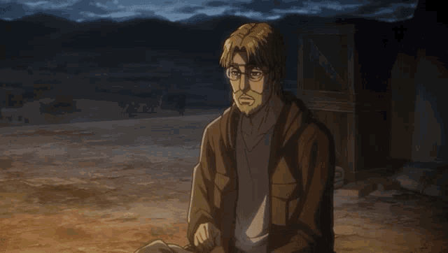 a man with glasses and a beard is sitting in the dirt