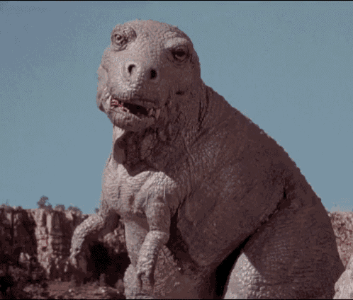 a dinosaur with its mouth open looks at the camera with a blue sky in the background