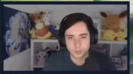 a man wearing headphones is sitting in a room with stuffed animals on a shelf .