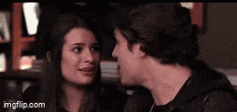 a man and a woman are looking into each other 's eyes in a room .