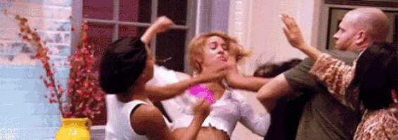 a group of people are having a fight in a room .