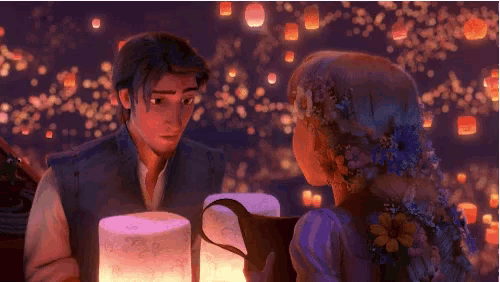 a man and a woman are looking at each other in front of lanterns floating in the air .