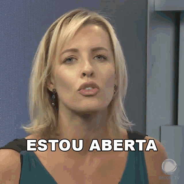 a woman says " estou aberta " in front of a blue wall