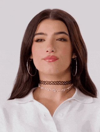 a woman wearing a choker and hoop earrings is making a face .