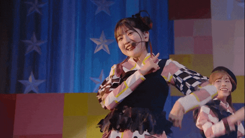 a girl with a microphone in her ear is dancing on stage