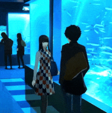 a man and a woman are standing in front of a fish tank