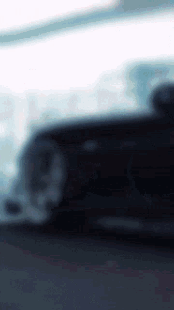 a blurry picture of a black car driving down a street