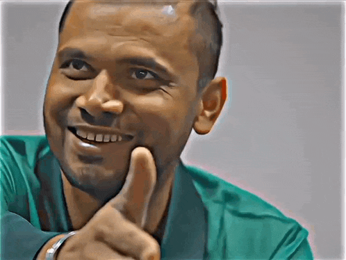 a man is smiling and giving a thumbs up sign