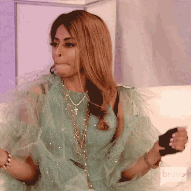 a woman in a green dress with a bravo logo on the bottom right
