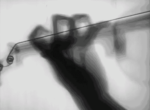 a blurry black and white photo of a person holding a wire .