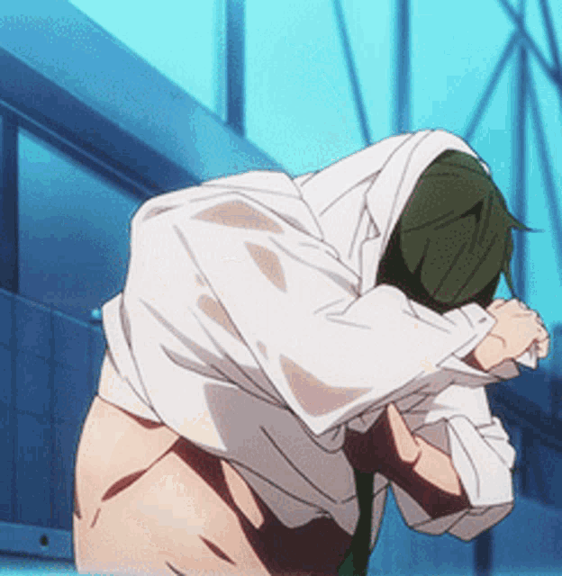 a man with a white shirt and green tie is kneeling down