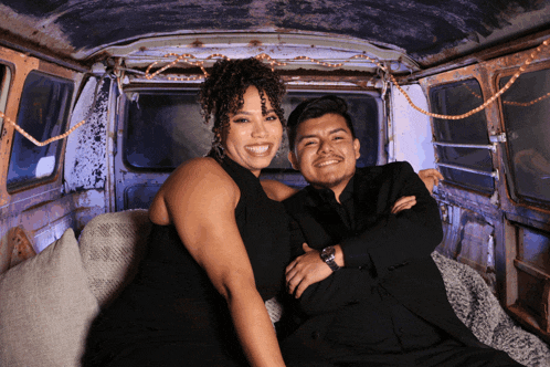 a man and a woman are posing for a photo in a van